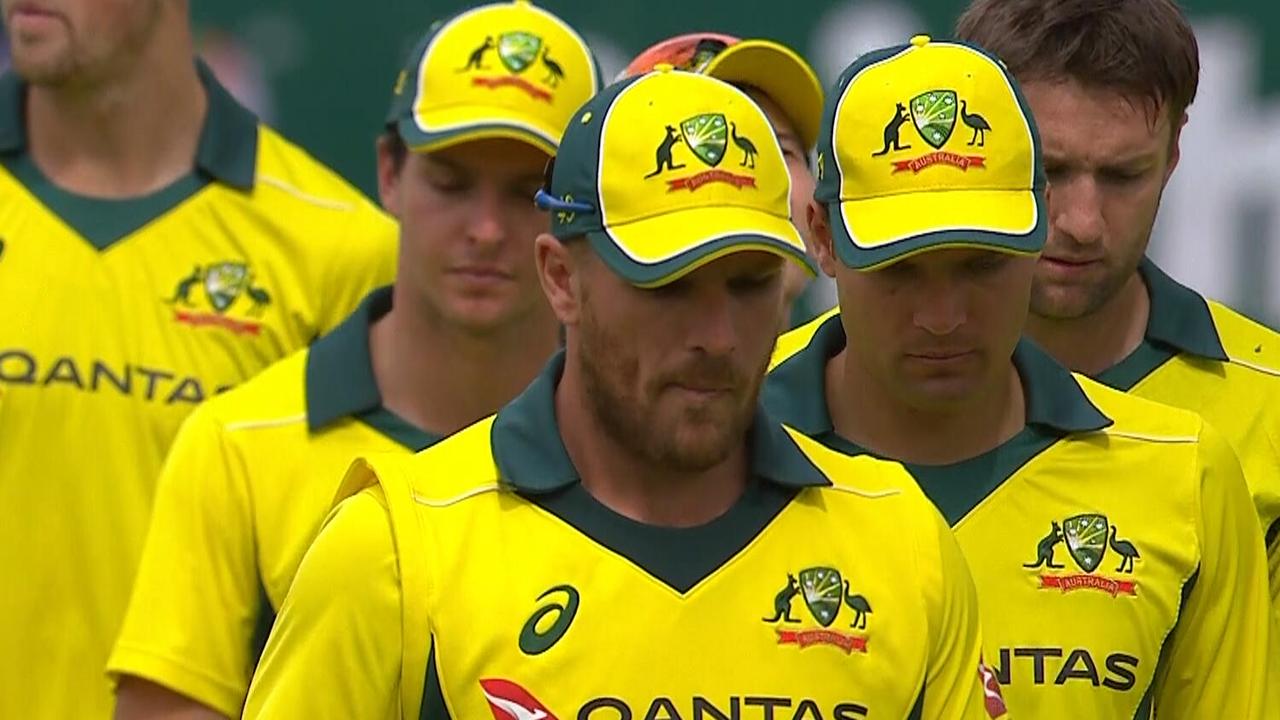 A dejected Aaron Finch leads Australia off.