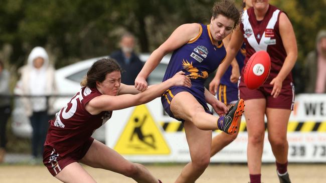 Vermont’s Annaliese Carroll kicks under grand final pressure from Mount Evelyn’s Skye Johnston    Picture: Hamish Blair