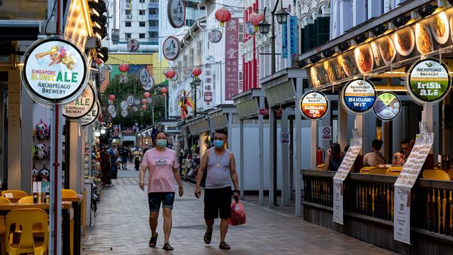 Shoppers wearing masks walk down Singapore’s Chinatown, a popular strip usually bustling with tourists. Picture: Getty Images