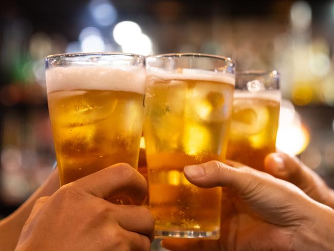 Group of happy friends drinking and toasting beer at brewery bar restaurant - Friendship concept with young people having fun together at cool vintage pub - Focus on middle pint glass