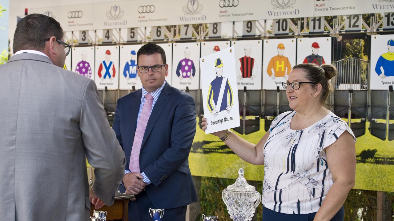 Lizzy King lending a hand at this year's public Weetwood barrier draw with Wippells Autos dealer principal David Russell (left) and Toowoomba chief steward Rion Hitchener. Picture: Kevin Farmer.