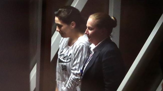 Bernadette Burns, centre, being escorted into Adelaide Airport by a detective after her arrest. Picture: Simon Cross.