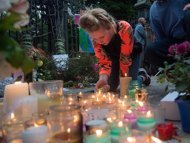 A young girl lights candles at a memorial site at the Botanical garden in Christchurch. Picture: AFP 