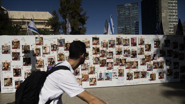 A man rides a bicycle near a wall covered with photos of hostages kidnapped by Hamas, in Tel Aviv, Israel. Picture: Getty