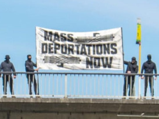 The group of masked protesters on the Morphett St bridge in Adelaide Picture: 7NEWS