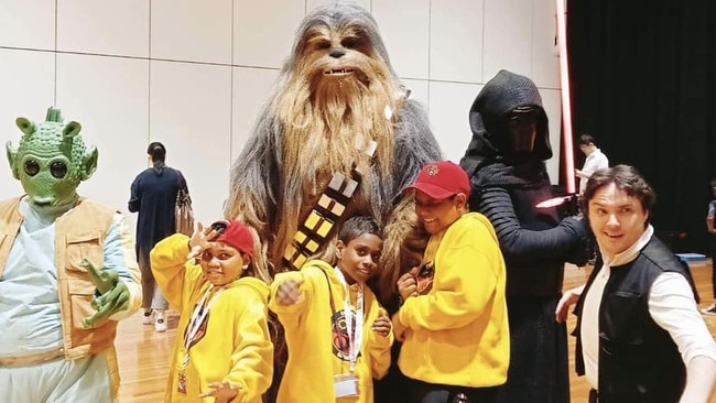 Dhupuma Barker School students Cyrus, Sean, and Richard pose with Star Wars characters at the VEX Robotics Australia National Championships. Picture: Supplied