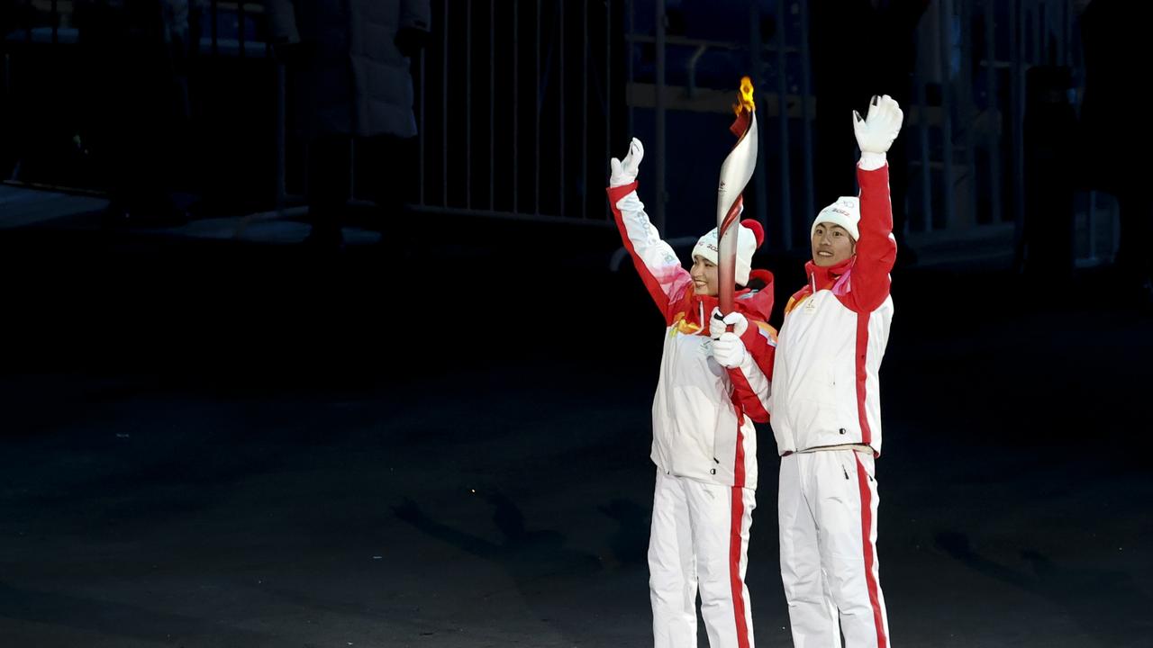 BEIJING, CHINA - FEBRUARY 4: Torch bearers Dinigeer Yilamujiang and Jiawen Zhao of Team China light up the Olympic flame during the Opening Ceremony of the Beijing 2022 Winter Olympics at Beijing National Stadium on February 4, 2022 in Beijing, China. (Photo by Jean Catuffe/Getty Images,)