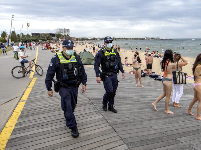 Police patrol a crowded St Kilda beach as restrictions ease. Picture: David Geraghty