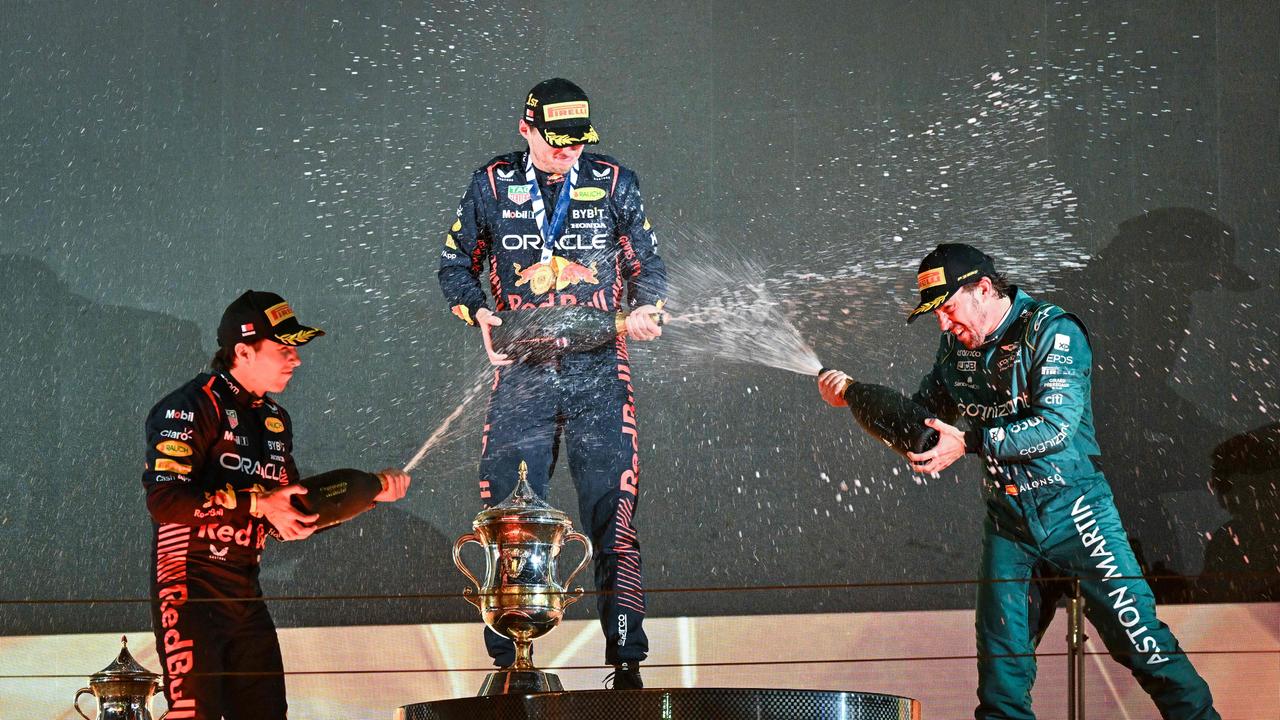 Sergio Perez, Max Verstappen and Fernando Alonso celebrate on the podium after the Bahrain Grand Prix. (Photo by ANDREJ ISAKOVIC / AFP)