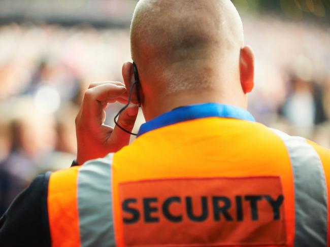 Rear view of a security guard listening to his headset. Generic photo of security guard.