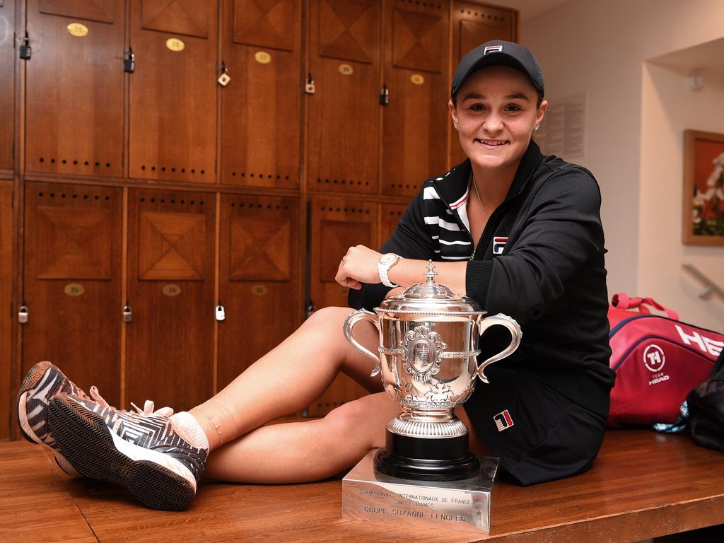 Ash Barty celebrates victory with the winners trophy in the dressing room. (Photo by Corinne Dubreuil/FFT-Pool/Getty Images)