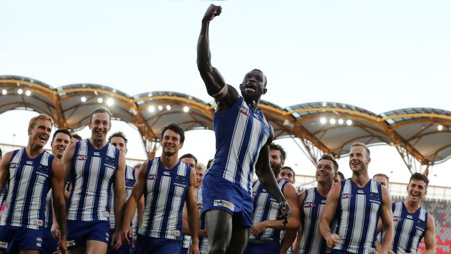 Majak Daw celebrates his first game back as he leads the Kangaroos off Metricon Stadium . Picture: Michael Klein