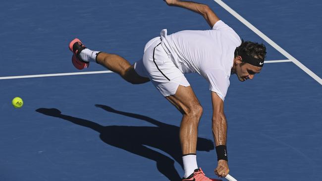 Roger Federer reaches for a backhand return to Hungary's Marton Fucsovics during their fourth round match on Monday. Picture: AP.