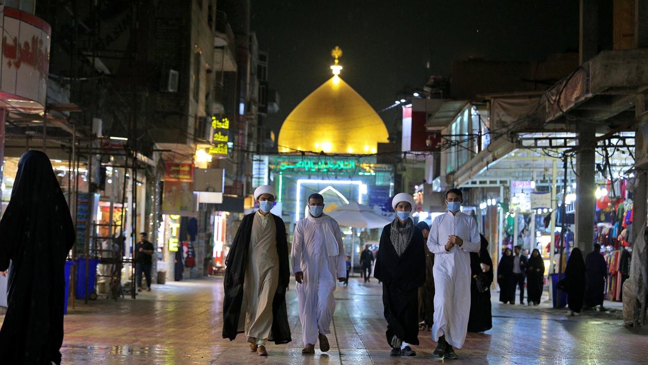 Shiite pilgrims wear masks outside the shrine of Imam Ali in Najaf, Iraq. Picture: AP/Anmar Khalil