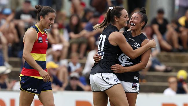 Carlton’s Nicola Stevens celebrates her goal with skipper Darcy Vescio while Crows Angela Foley walks back. Picture: Sarah Reed