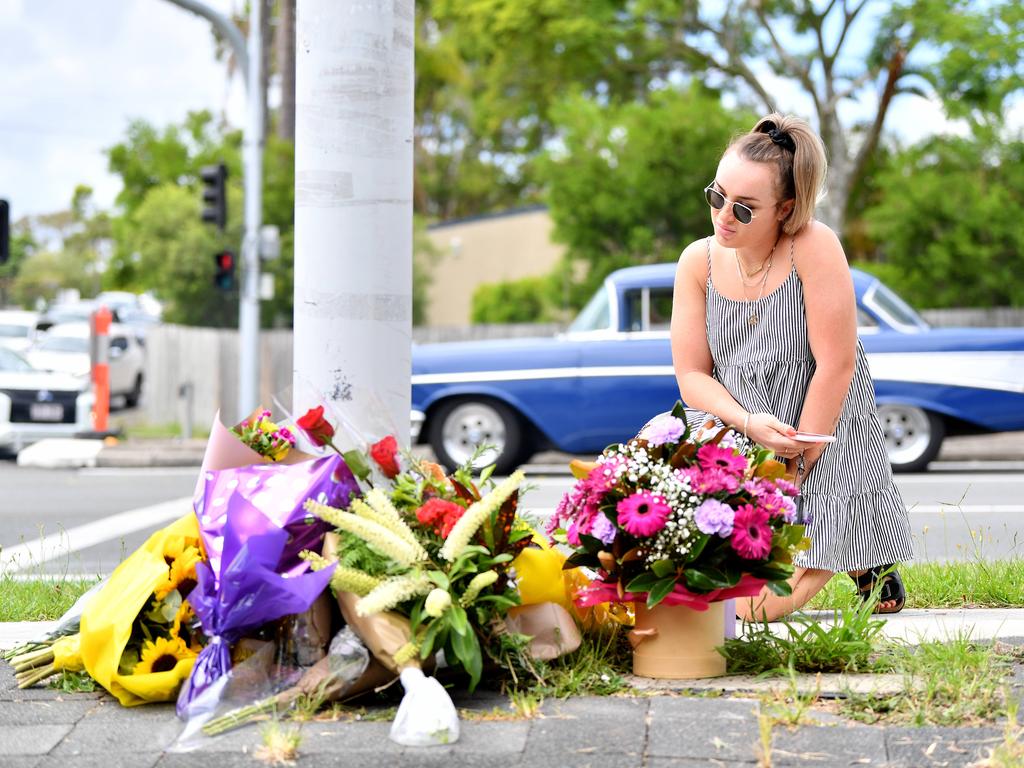 A woman placed flowers at a makeshift shrine where a couple walking their dog were hit and killed in a crash involving an allegedly stolen car, at Alexandra Hills in Brisbane's east. Picture: NCA NewsWire / Dan Peled