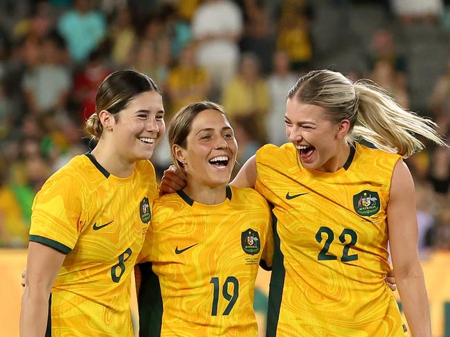 MELBOURNE, AUSTRALIA – FEBRUARY 28: Kyra Cooney-Cross of Australia, Katrina Gorry of Australia and Charlotte Grant of Australia celebrate after winning the AFC Women's Olympic Football Tournament Paris 2024 Asian Qualifier Round 3 match between Australia Matildas and Uzbekistan at Marvel Stadium on February 28, 2024 in Melbourne, Australia. (Photo by Robert Cianflone/Getty Images)