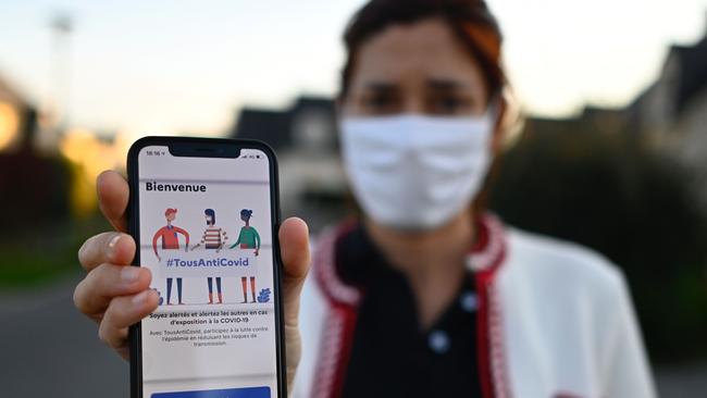 A woman holds a ‘TousAntiCovid’ application in Rennes, western France. Picture: AFP