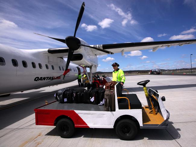 A QANTAS baggage handler prepares for a flight leaving Canberra for Sydney ahead of planned afternoon work strikes involving industrial action relating to baggage handlers, aircraft mechanics.  Pic - Sam Mooy