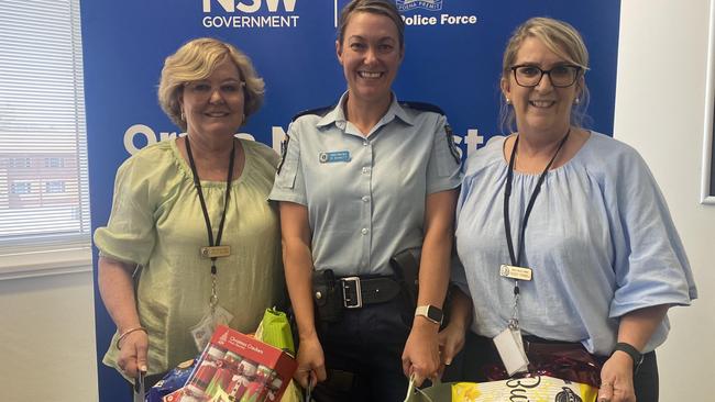 Staying Home Leaving Violence case manager Kate Hilder, Senior Constable Melissa Bennett and case manager Tracey Connell holding Christmas hampers.