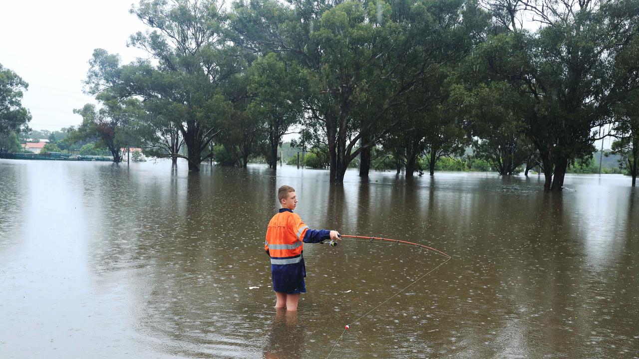 Brian Cooper fishes at flooded Church Street in Windsor. Picture: John Feder