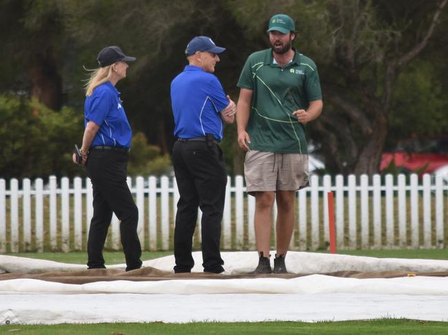 Umpires and ground staff deliberate over the Kensington pitch. Picture: Sean Teuma