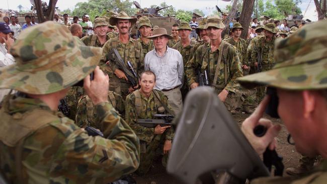 Prime minister John Howard poses with Australian peacekeepers at the East Timorese city of Maliana during a visit in November 1999. Picture: Andrew Meares