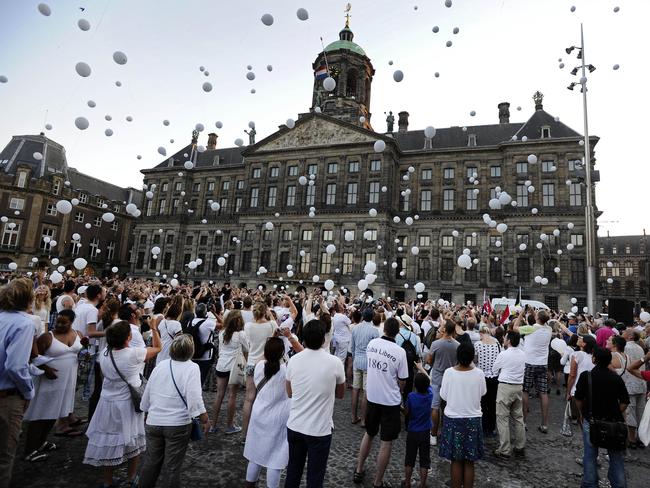People release white balloons in the air during a silent march in memory of the victims of the downed Malaysia Airlines flight MH17. Picture: AFP Photo/Olaf Kraak.