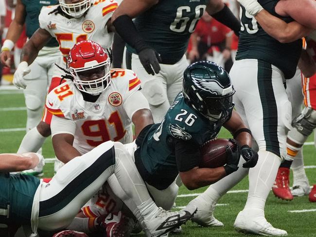 Philadelphia Eagles' running back #26 Saquon Barkley holds on to the football as he is tackled during Super Bowl LIX between the Kansas City Chiefs and the Philadelphia Eagles at Caesars Superdome in New Orleans, Louisiana, February 9, 2025. (Photo by TIMOTHY A. CLARY / AFP)