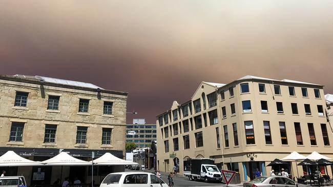 Smoke from an out-of-control bushfire burning in the Wilderness World Heritage area in southwest Tasmania is visible from Salamanca Square in Hobart, Friday, January 4, 2019. (AAP Image/Ethan James)