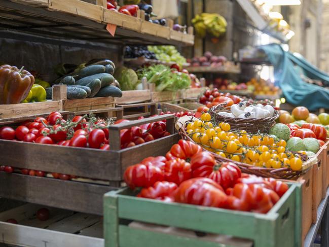 Fresh and healthy vegetables and colorful fruit in front of a shop in a picturesque street in Italy