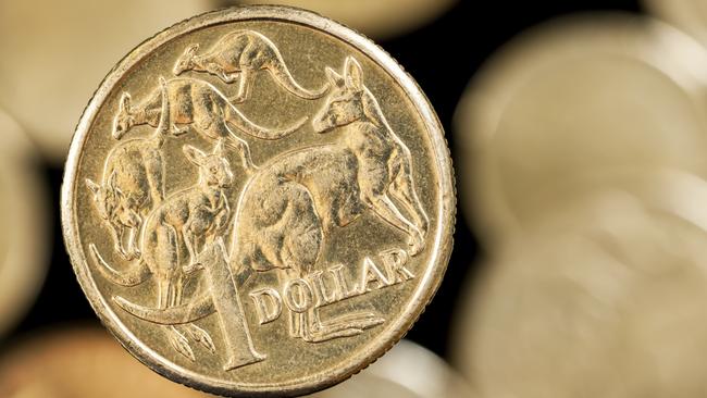 Australian one dollar coin over blurred golden background.