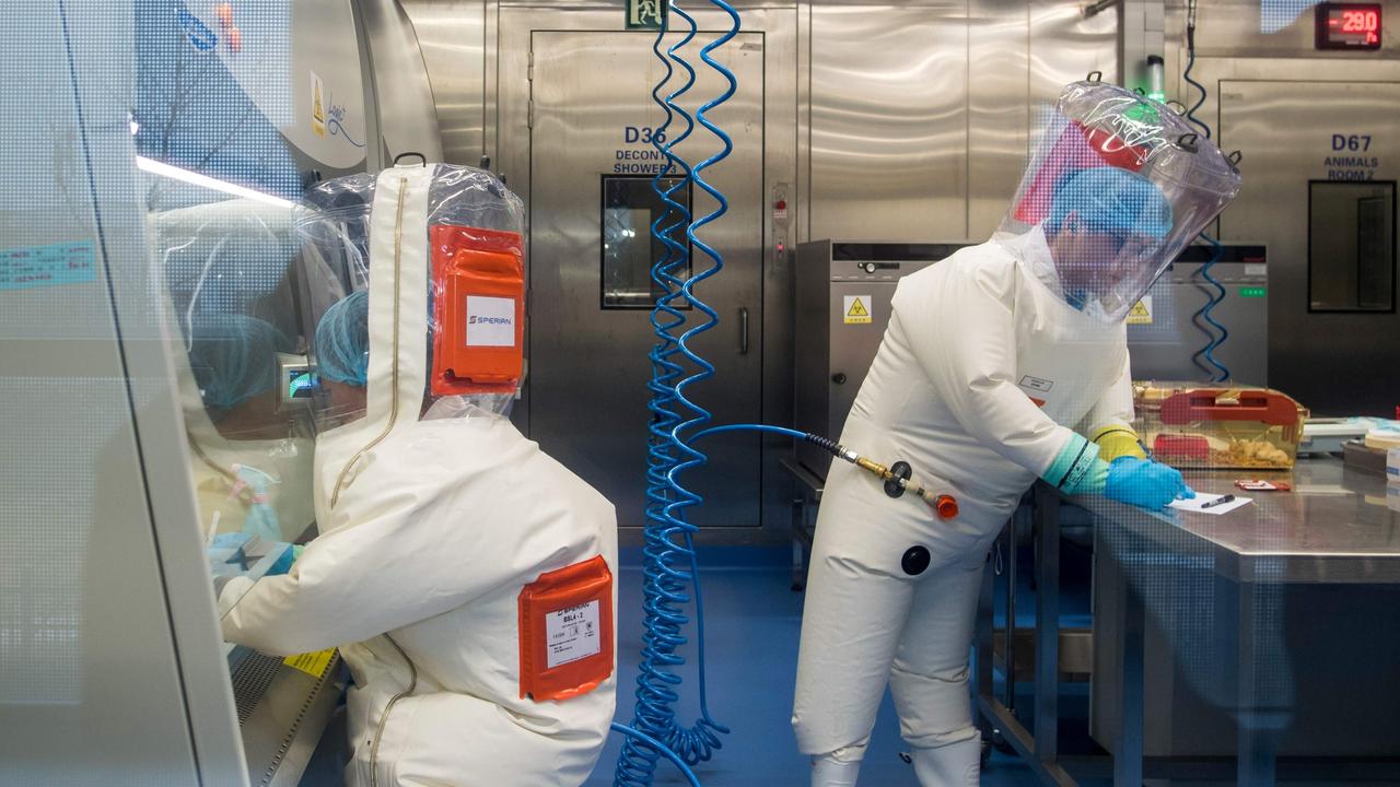 Workers next to a cage with mice inside the P4 laboratory in Wuhan. Picture: AFP