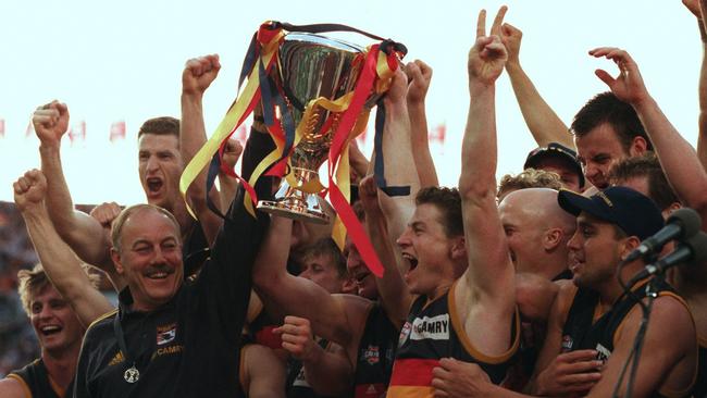 Crows coach Malcolm Blight (left) and captain Mark Bickley raise the 1998 AFL premiership cup with the team.