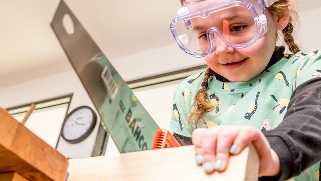 Evie, 5, focuses as she uses a sharp saw. Picture: Tim Carrafa