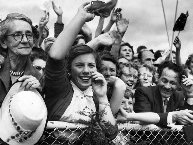 Melburnians wave as Queen Elizabeth II walks to her plane at Essendon Airport in 1954. Picture: HWT Library.