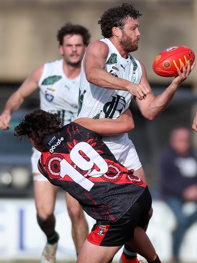 Echuca’s Sam Reid manages to get a handball away despite pressure from Kyabram’s Charlie Barnett.