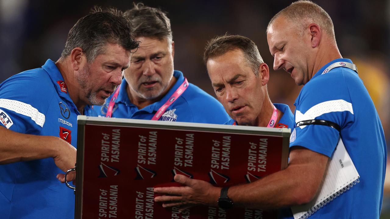 Alastair Clarkson and his coaching assistants work on the player magnets as they ring in the changes at quarter time. Picture: Michael Klein