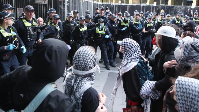 Activists approach police outside the Melbourne Convention Centre. Picture: David Crosling