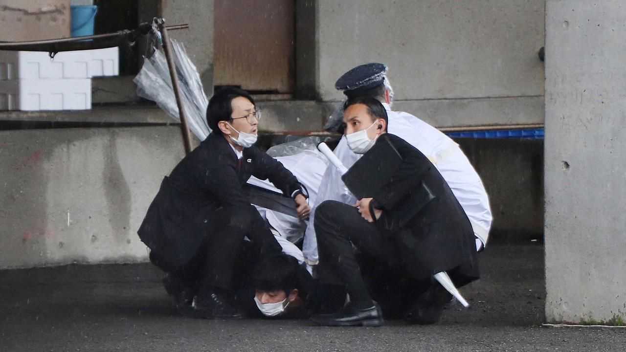 A man (bottom) is arrested after throwing what appeared to be a smoke bomb in Wakayama. Picture: JIJI Press / AFP / Japan OUT