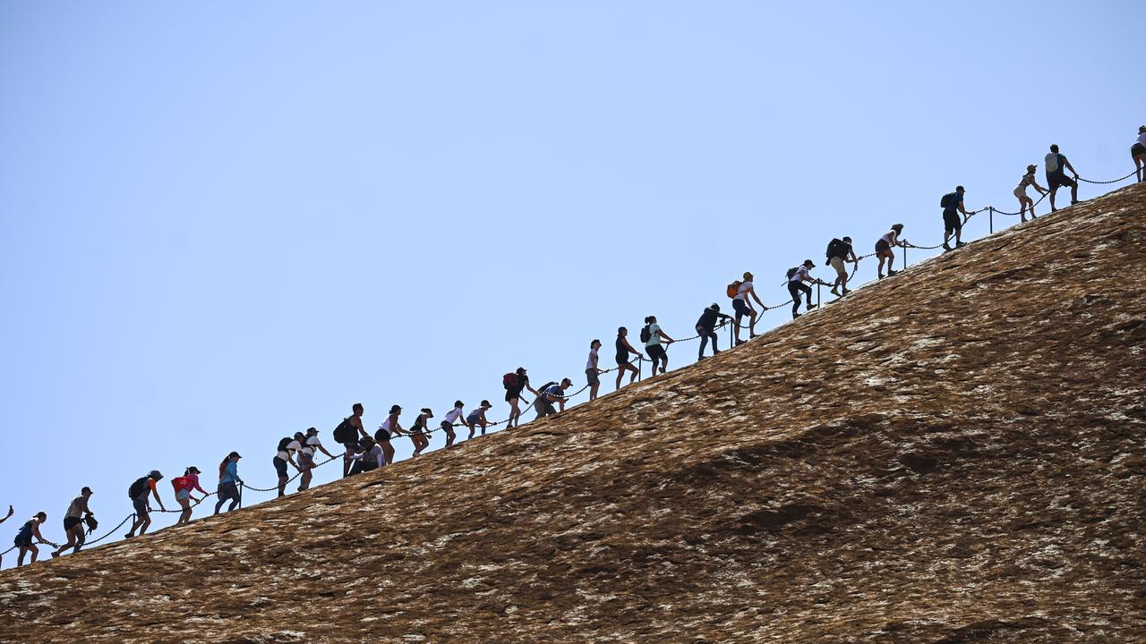 Tourists climbing Uluru on Friday, the last day that the climb was open to the public. Picture: AAP Image/Lukas Coch