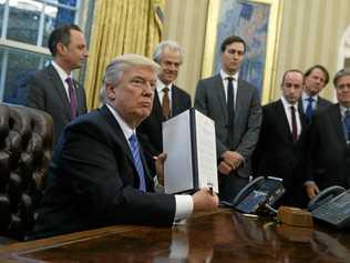 President Donald Trump shows off a signed executive order. The loss of trust in the political establishment which contributed to Trump's election will be put under the microscope to determine the implications for Queensland at the upcoming Queensland election. Picture: Evan Vucci