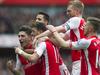 Arsenal's Mesut Özil, second from left, celebrates with team mates, from left, Hector Bellerin, Alexis Sanchez, Per Mertesacker and Aaron Ramsey after scoring against Liverpool, during their English Premier League soccer match, at Emirates Stadium, in London, Saturday, April 4, 2015. (AP Photo/Bogdan Maran)