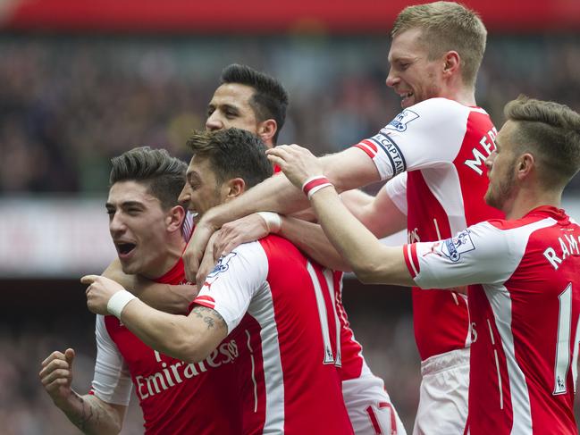 Arsenal's Mesut Özil, second from left, celebrates with team mates, from left, Hector Bellerin, Alexis Sanchez, Per Mertesacker and Aaron Ramsey after scoring against Liverpool, during their English Premier League soccer match, at Emirates Stadium, in London, Saturday, April 4, 2015. (AP Photo/Bogdan Maran)