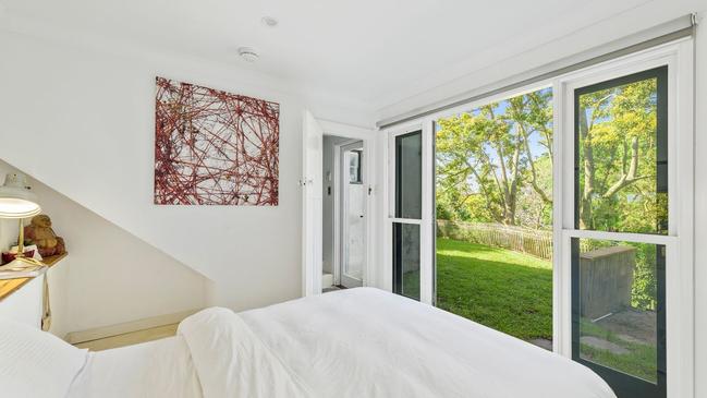 A bedroom looking out to greenery.