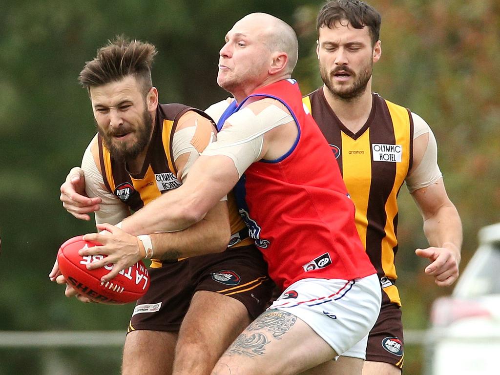 Northern: Heidelberg West’s Jack Marris is wrapped up by Michael Evans of Mernda.