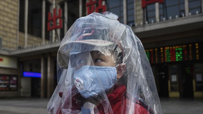 BEIJING, CHINA - FEBRUARY 12: A Chinese boy is covered in a plastic bag for protection as he arrives from a train at Beijing Station on February 12, 2020 in Beijing, China. The number of cases of a deadly new coronavirus rose to more than 44000 in mainland China Wednesday, days after the World Health Organization (WHO) declared the outbreak a global public health emergency. China continued to lock down the city of Wuhan in an effort to contain the spread of the pneumonia-like disease which medicals experts have confirmed can be passed from human to human. In an unprecedented move, Chinese authorities have put travel restrictions on the city which is the epicentre of the virus and municipalities in other parts of the country affecting tens of millions of people. The number of those who have died from the virus in China climbed to over 1100 on Wednesday, mostly in Hubei province, and cases have been reported in other countries including the United States, Canada, Australia, Japan, South Korea, India, the United Kingdom, Germany, France and several others. The World Health Organization has warned all governments to be on alert and screening has been stepped up at airports around the world. Some countries, including the United States, have put restrictions on Chinese travellers entering and advised their citizens against travel to China. (Photo by Kevin Frayer/Getty Images) *** BESTPIX ***