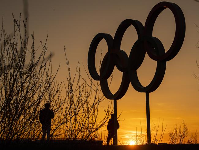 LONDON, UNITED KINGDOM  - MARCH 23: People pose for pictures in front of the Olympic rings in the Olympic Park in Stratford as Tokyo Olympics organisers are considering options to delay the Olympics with teams treating to pull out due to the coronavirus on March 23, 2020 in London, England. Coronavirus (COVID-19) pandemic has spread to at least 182 countries, claiming over 10,000 lives and infecting hundreds of thousands more. (Photo by Justin Setterfield/Getty Images)