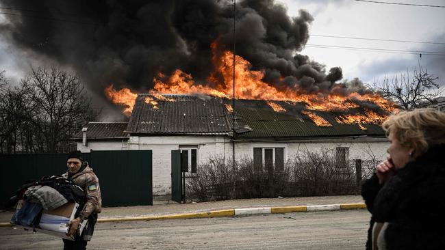 A man removes personal belongings from a burning house after being shelled in the city of Irpin, outside Kyiv. Picture: AFP