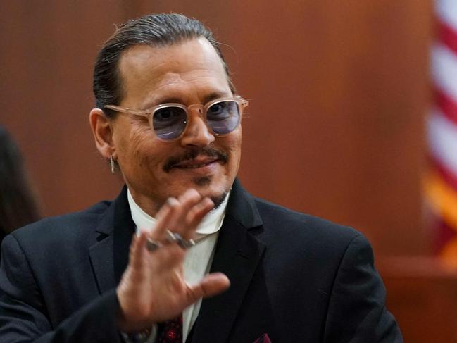 Actor Johnny Depp acknowledges supporters during a break in his defamation trial against his ex-wife Amber Heard. (Photo by KEVIN LAMARQUE / POOL / AFP)